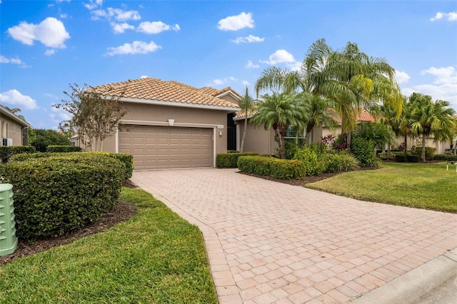 mediterranean / spanish home with a garage and a front lawn