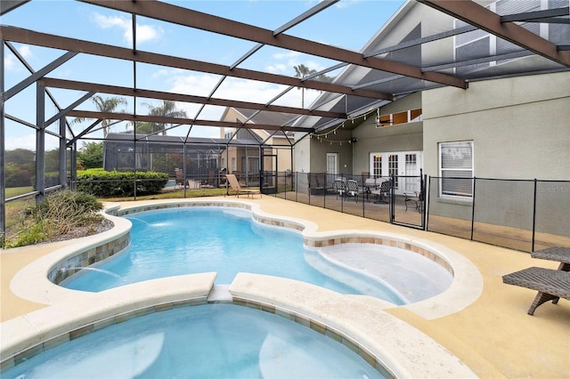 view of pool featuring a patio area, an in ground hot tub, and glass enclosure