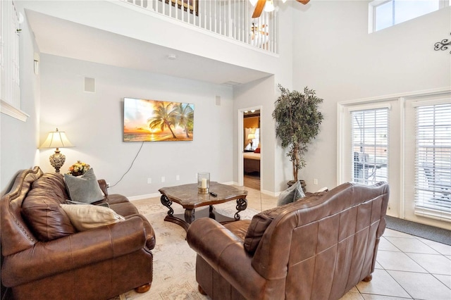 tiled living room with a high ceiling and ceiling fan