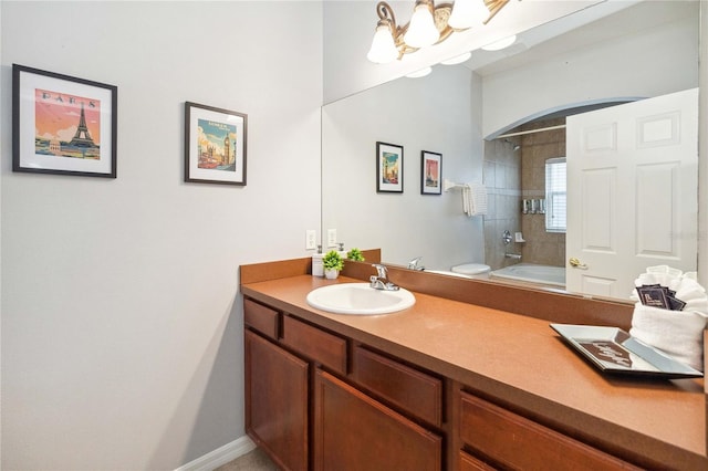 bathroom featuring vanity, an inviting chandelier, and tiled shower / bath combo