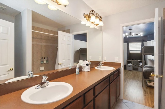 bathroom featuring tile patterned flooring, an inviting chandelier, and vanity