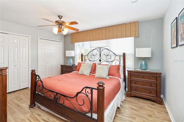 bedroom with ceiling fan, light hardwood / wood-style floors, and multiple closets