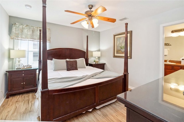 bedroom featuring ceiling fan, light hardwood / wood-style flooring, and connected bathroom