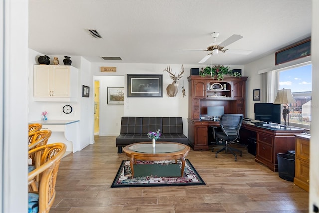 home office featuring ceiling fan and light hardwood / wood-style floors