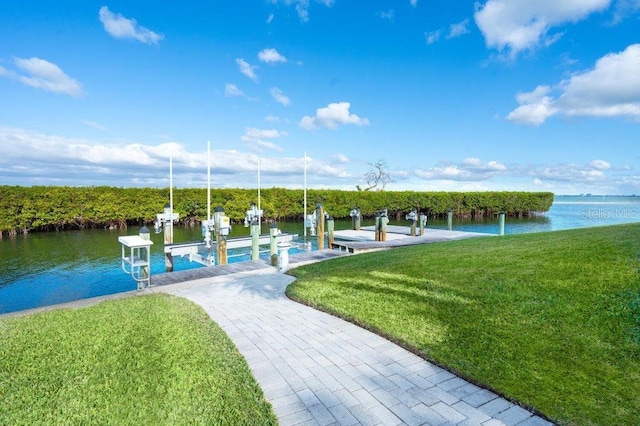 view of dock with a yard and a water view