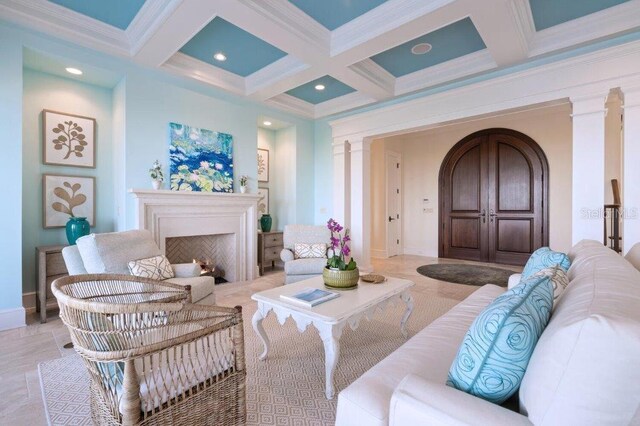 living room featuring coffered ceiling, beamed ceiling, decorative columns, and ornamental molding