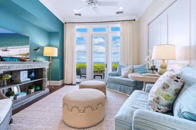 living area with a water view, hardwood / wood-style flooring, ceiling fan, and ornamental molding