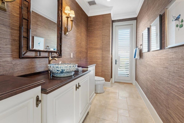 bathroom featuring toilet, vanity, and ornamental molding