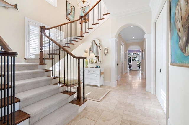 foyer entrance featuring a high ceiling and ornamental molding