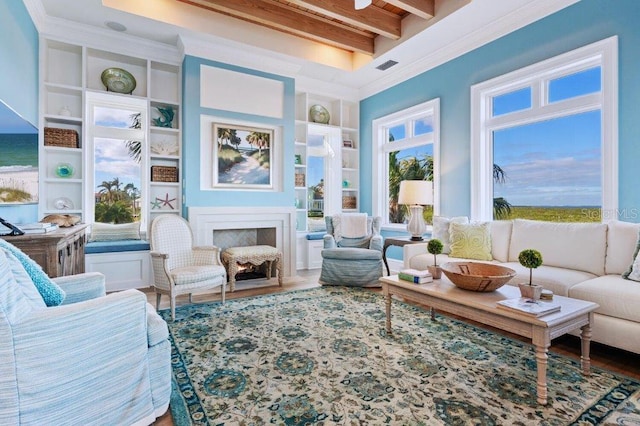 sunroom with ornamental molding, hardwood / wood-style flooring, built in shelves, and beam ceiling