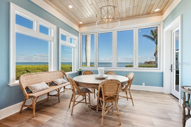 sunroom with plenty of natural light, an inviting chandelier, and wooden ceiling