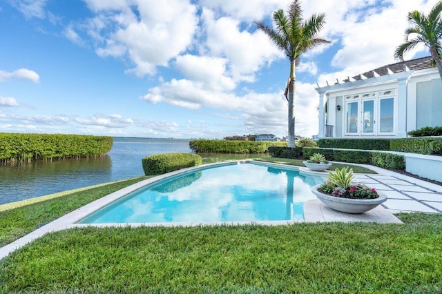 view of swimming pool featuring a yard and a water view