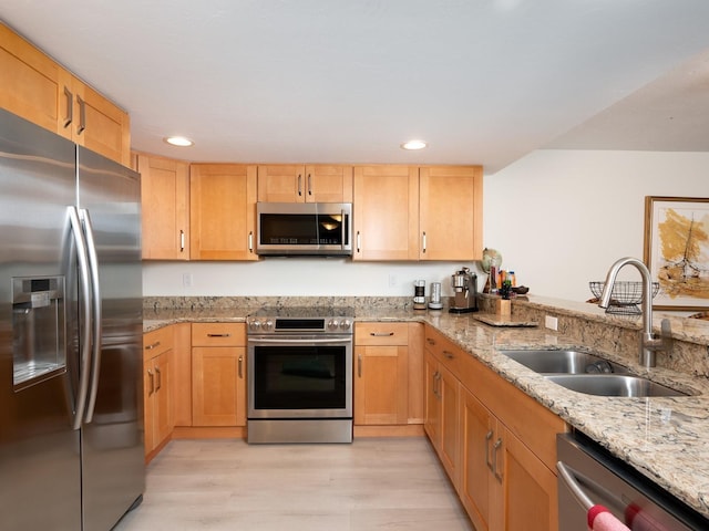 kitchen featuring sink, light hardwood / wood-style flooring, appliances with stainless steel finishes, light stone countertops, and light brown cabinets