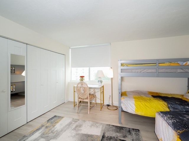 bedroom with light hardwood / wood-style floors and a closet