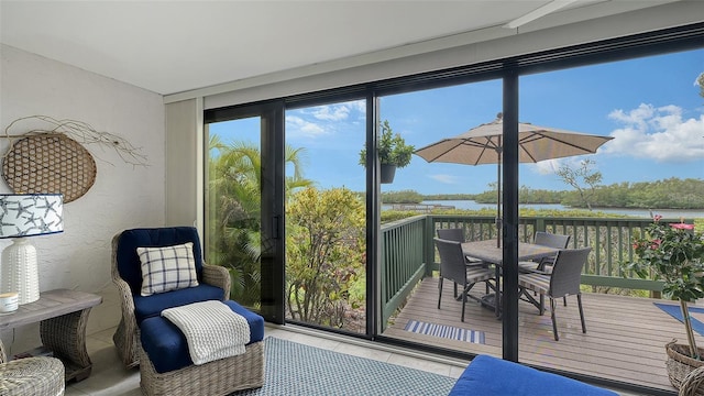 sunroom featuring a water view