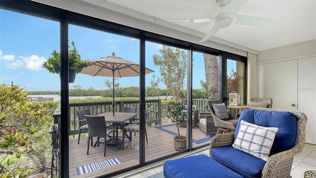 interior space featuring a water view, ceiling fan, and light tile patterned floors