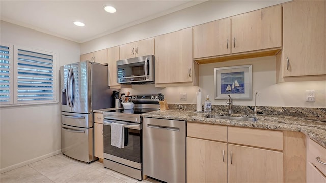 kitchen with light brown cabinetry, sink, light tile patterned floors, stainless steel appliances, and light stone countertops