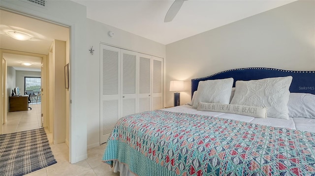 bedroom with ceiling fan, a closet, and light tile patterned floors