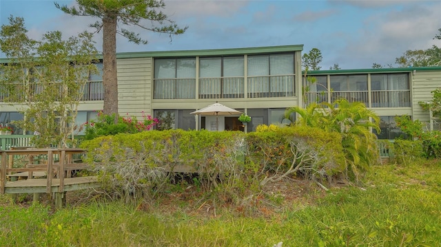 rear view of property featuring a sunroom