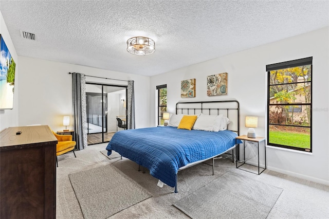 carpeted bedroom featuring access to outside and a textured ceiling