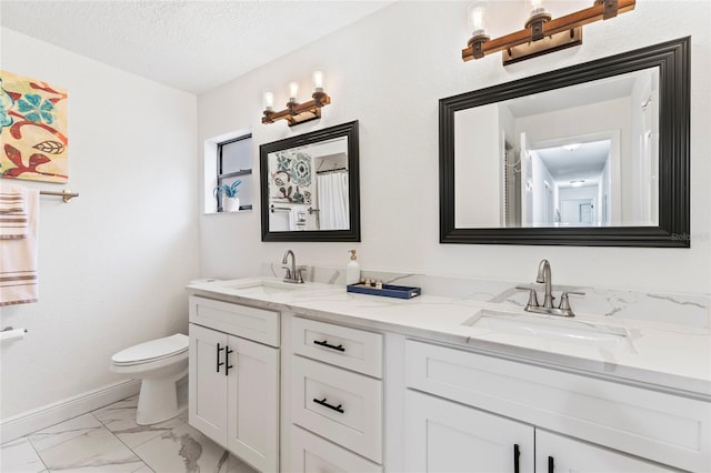 bathroom featuring vanity, toilet, and a textured ceiling