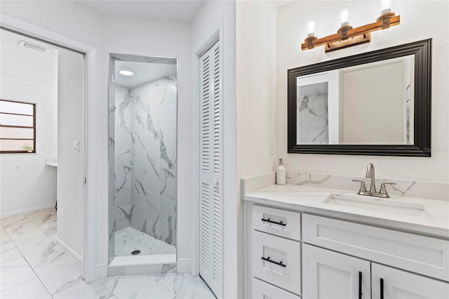 bathroom with tiled shower and vanity