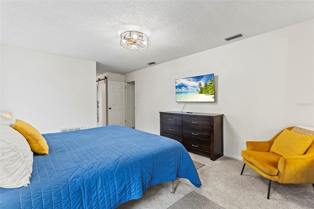 bedroom with light colored carpet and a textured ceiling