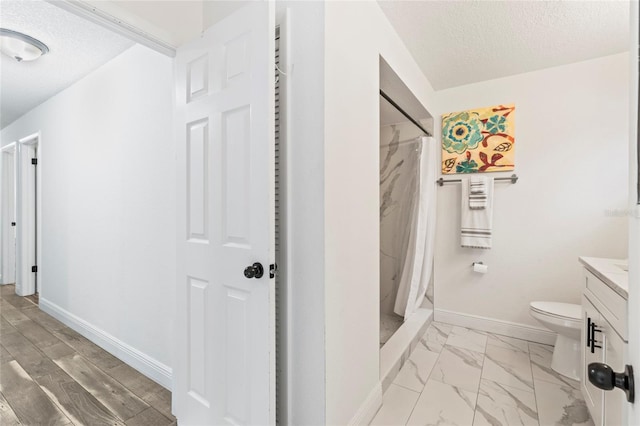 bathroom with vanity, walk in shower, a textured ceiling, and toilet