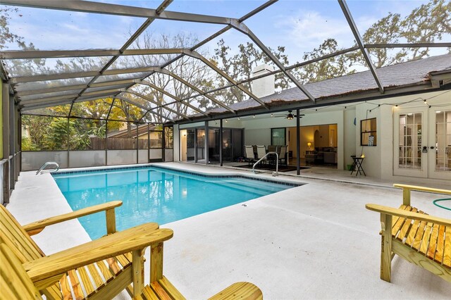 view of swimming pool featuring french doors, a lanai, ceiling fan, and a patio area