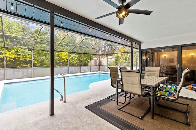 view of swimming pool with a patio area, ceiling fan, and glass enclosure