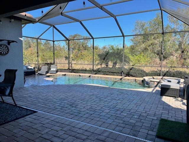 view of swimming pool featuring a lanai and a patio area