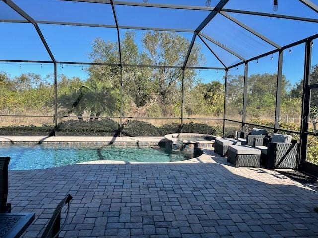 view of swimming pool with a lanai, an outdoor hangout area, a patio, and an in ground hot tub