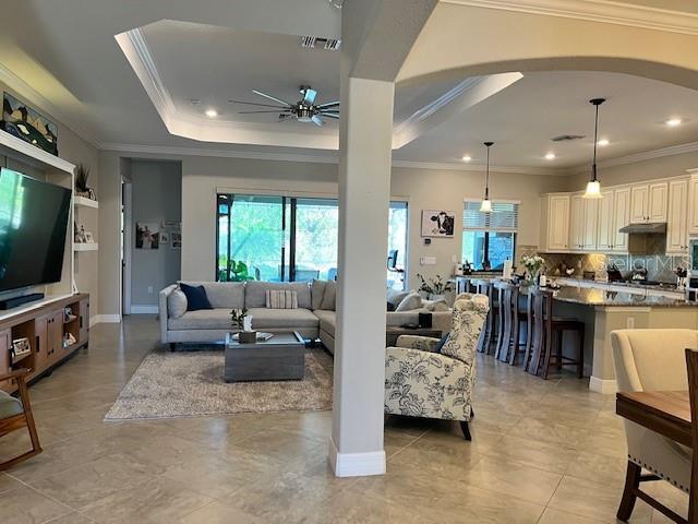 living room featuring ceiling fan and ornamental molding