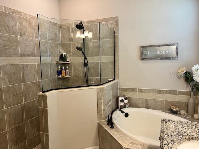 bathroom with vanity and plus walk in shower