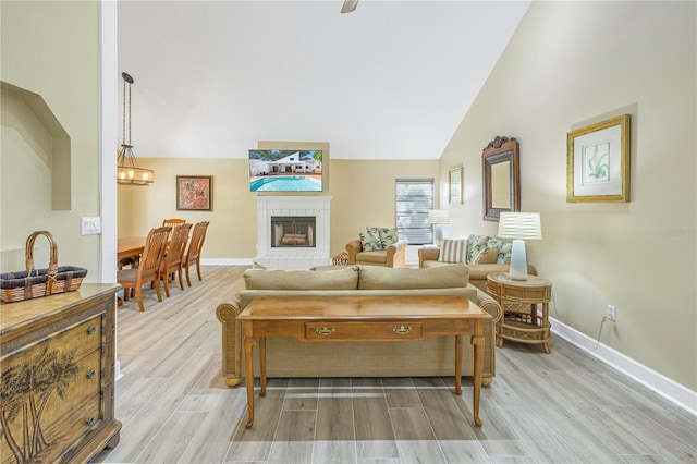 living room with lofted ceiling, light hardwood / wood-style floors, and a notable chandelier