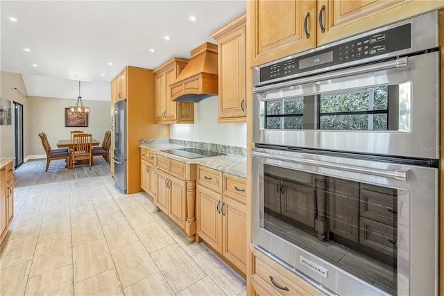 kitchen featuring custom exhaust hood, light stone counters, light brown cabinets, appliances with stainless steel finishes, and a notable chandelier