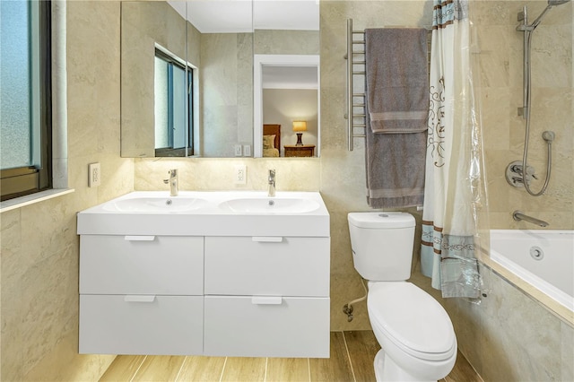 full bathroom with shower / bath combo, hardwood / wood-style floors, vanity, and tile walls