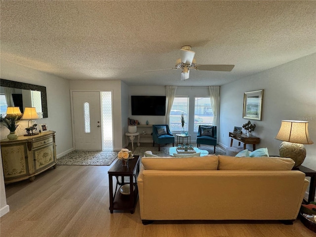 living room with a textured ceiling, hardwood / wood-style floors, and ceiling fan