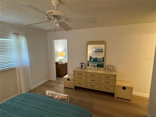 bedroom with wood-type flooring, a textured ceiling, and ceiling fan