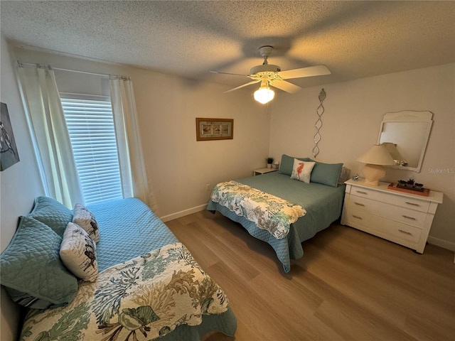 bedroom with ceiling fan, light hardwood / wood-style floors, and a textured ceiling