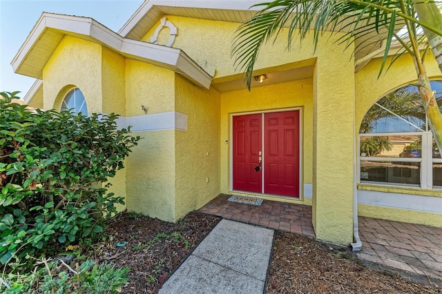 property entrance with stucco siding