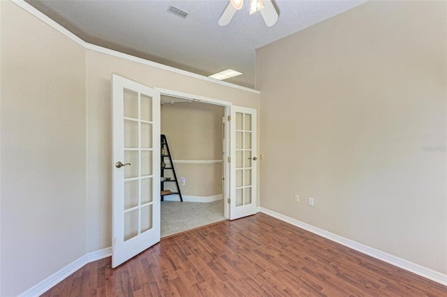 spare room featuring ornamental molding, ceiling fan, french doors, and wood-type flooring