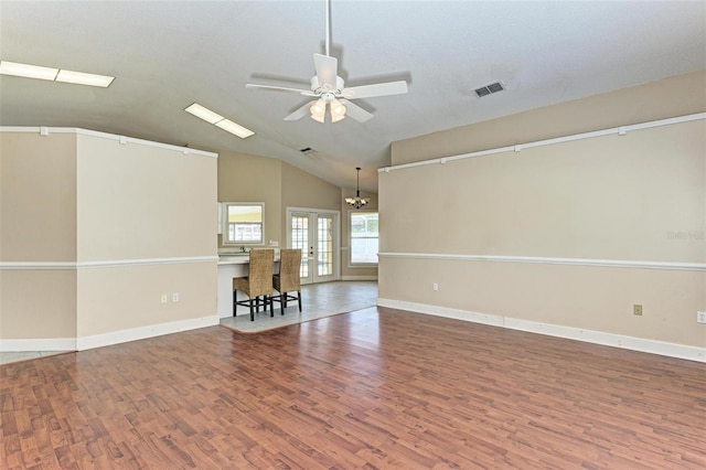 unfurnished room with lofted ceiling, french doors, wood-type flooring, and ceiling fan with notable chandelier