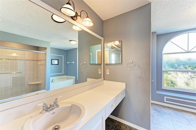 bathroom with tile patterned floors, separate shower and tub, a textured ceiling, and vanity