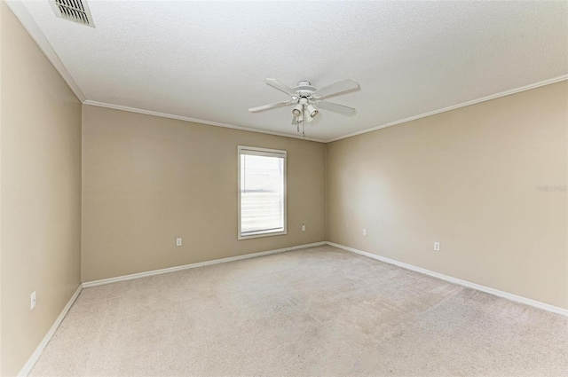 spare room with ornamental molding, light colored carpet, ceiling fan, and a textured ceiling