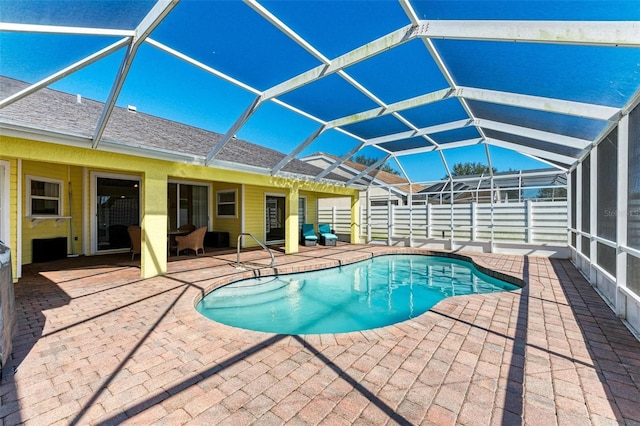 view of swimming pool featuring a patio and glass enclosure