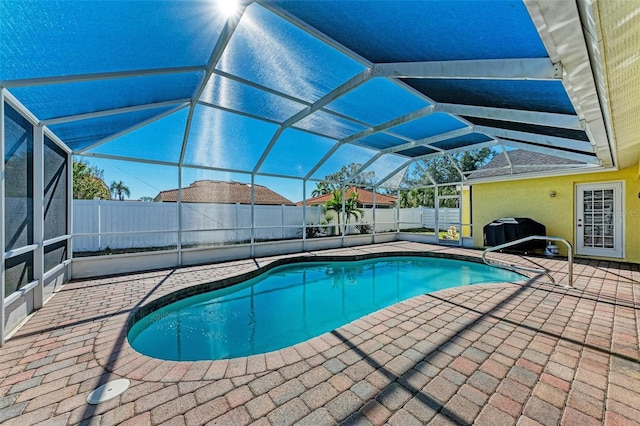 view of swimming pool featuring grilling area, a patio area, and glass enclosure