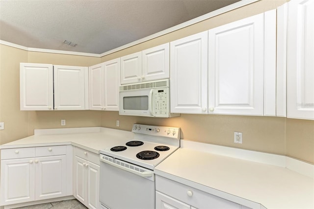 kitchen with white appliances, white cabinets, light tile patterned flooring, and a textured ceiling