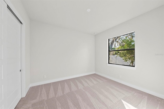 unfurnished bedroom with light carpet and a closet