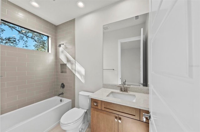 full bathroom featuring toilet, vanity, and tiled shower / bath